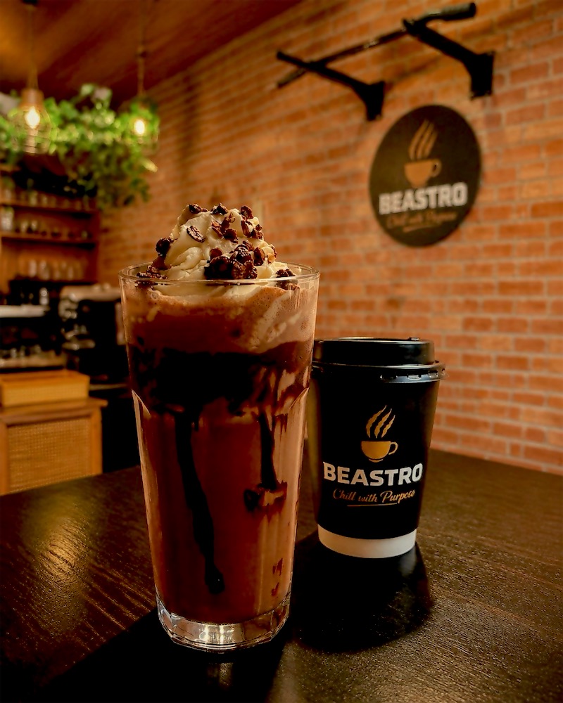 Chocolate Beast protein shake with whipped cream beside a Beastro cup