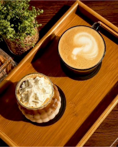 Hot latte and iced signature coffee on a wooden tray